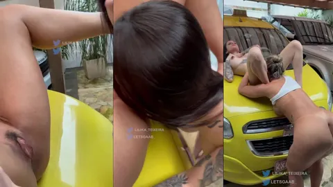 Lilika Teixeira e lestGaab a morena tatuada fazendo uma troca de orol encima do capô do te